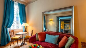 A cozy living room with a red sofa, a wooden coffee table, and a blue chair. - La Maison d'été (Salon-de-Provence)
