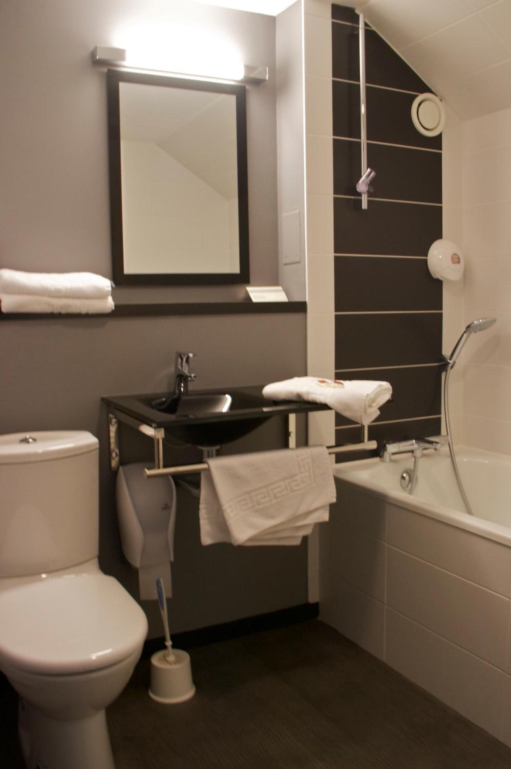 A modern bathroom with a toilet, sink, and bathtub.