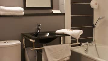 Un baño moderno con inodoro, lavamanos y bañera.