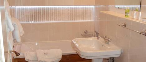 A modern bathroom with a bathtub, sink, and toilet.