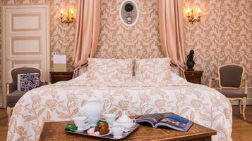 Une chambre à coucher avec un lit, une table de chevet sur laquelle se trouve un plateau avec du thé et des accessoires, et un livre.