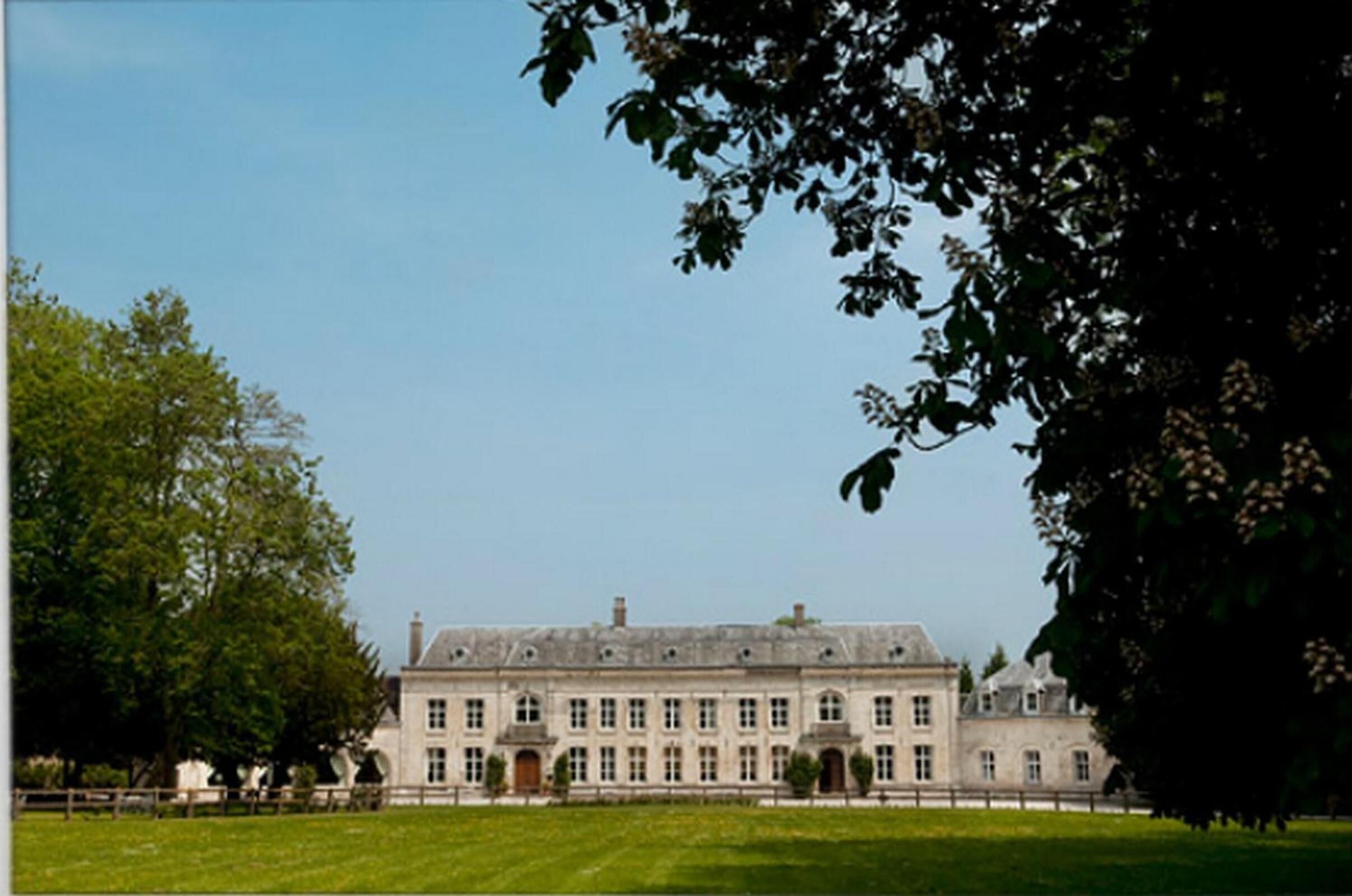 A large, historic building with a symmetrical facade, multiple windows, and a central entrance.