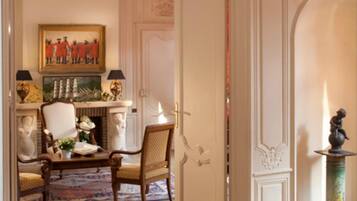 A room with a fireplace, a dining table with chairs, and a painting on the wall.