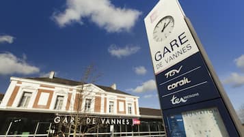 Un bâtiment sur lequel on peut lire l’inscription « GARE DE VANNES » et qui est surmonté d’une horloge.