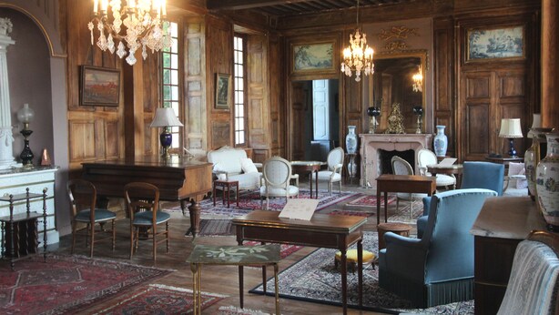 A spacious room with wooden paneling, a fireplace, and multiple seating areas including chairs and a sofa. - Château d'Island Avallon Vézelay (Island)