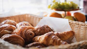 A basket of croissants on a table with a wicker basket and a white napkin.