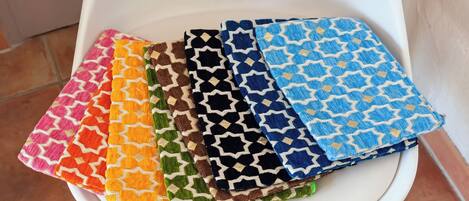 A stack of colorful, patterned fabric squares on a white chair.