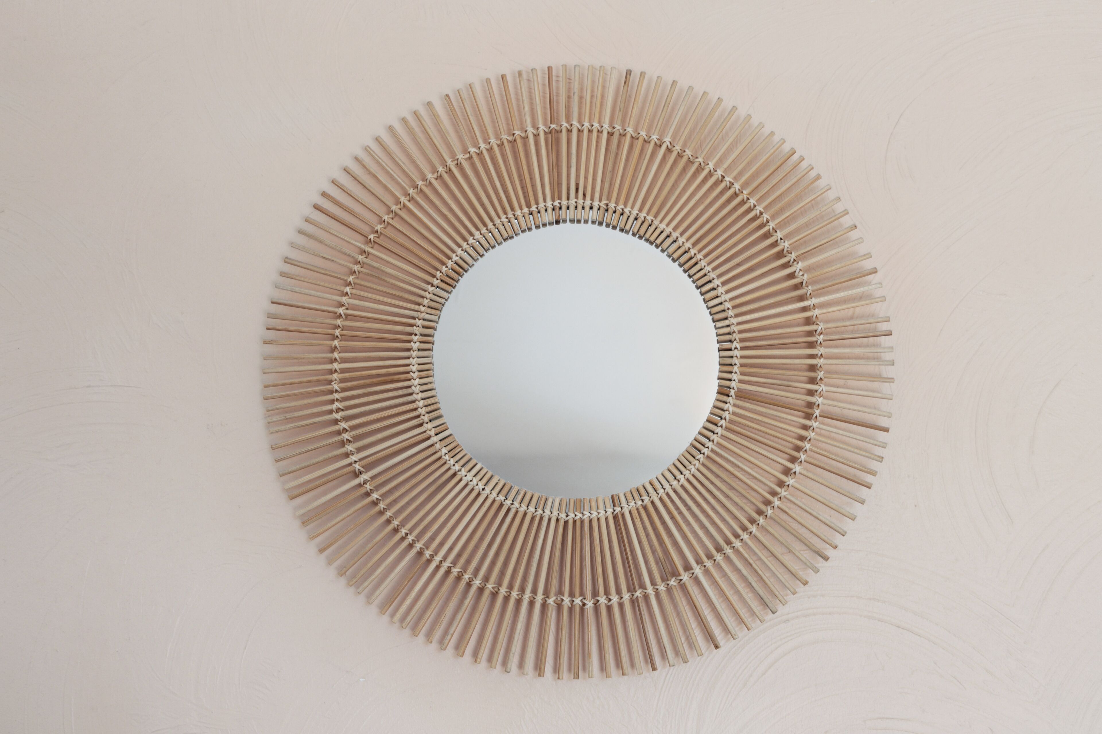 Un miroir rond avec un cadre en bois.