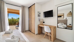 A hotel room with a bed, a desk, a chair, a TV, and a large mirror. - Hôtel La Nartelle (Sainte-Maxime)