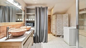 Une salle de bain moderne avec deux grands lavabos, un miroir et un espace douche.