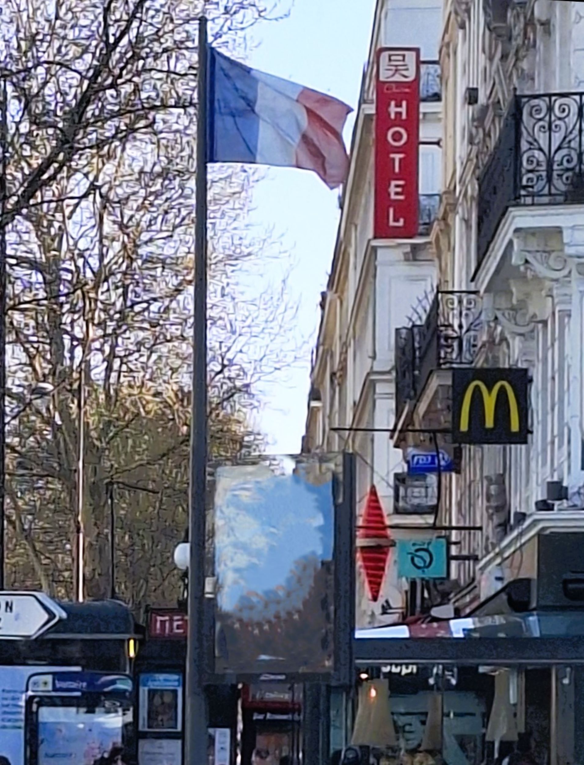 A hotel with a flag, a McDonald's sign, and a no parking sign.