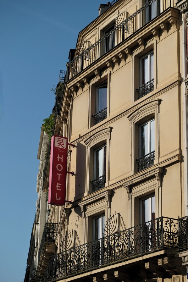 A hotel sign on a building with multiple windows and balconies. - Hipotel Paris Voltaire Bastille (Paris)