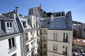 A multi-story building with various architectural styles, including a sloped roof and multiple chimneys. - Hipotel Paris Voltaire Bastille (Paris)