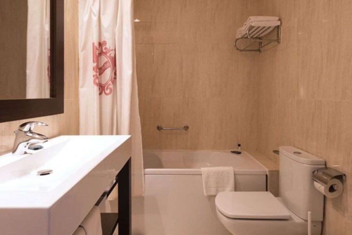 Une salle de bain avec un lavabo, des toilettes et une baignoire.