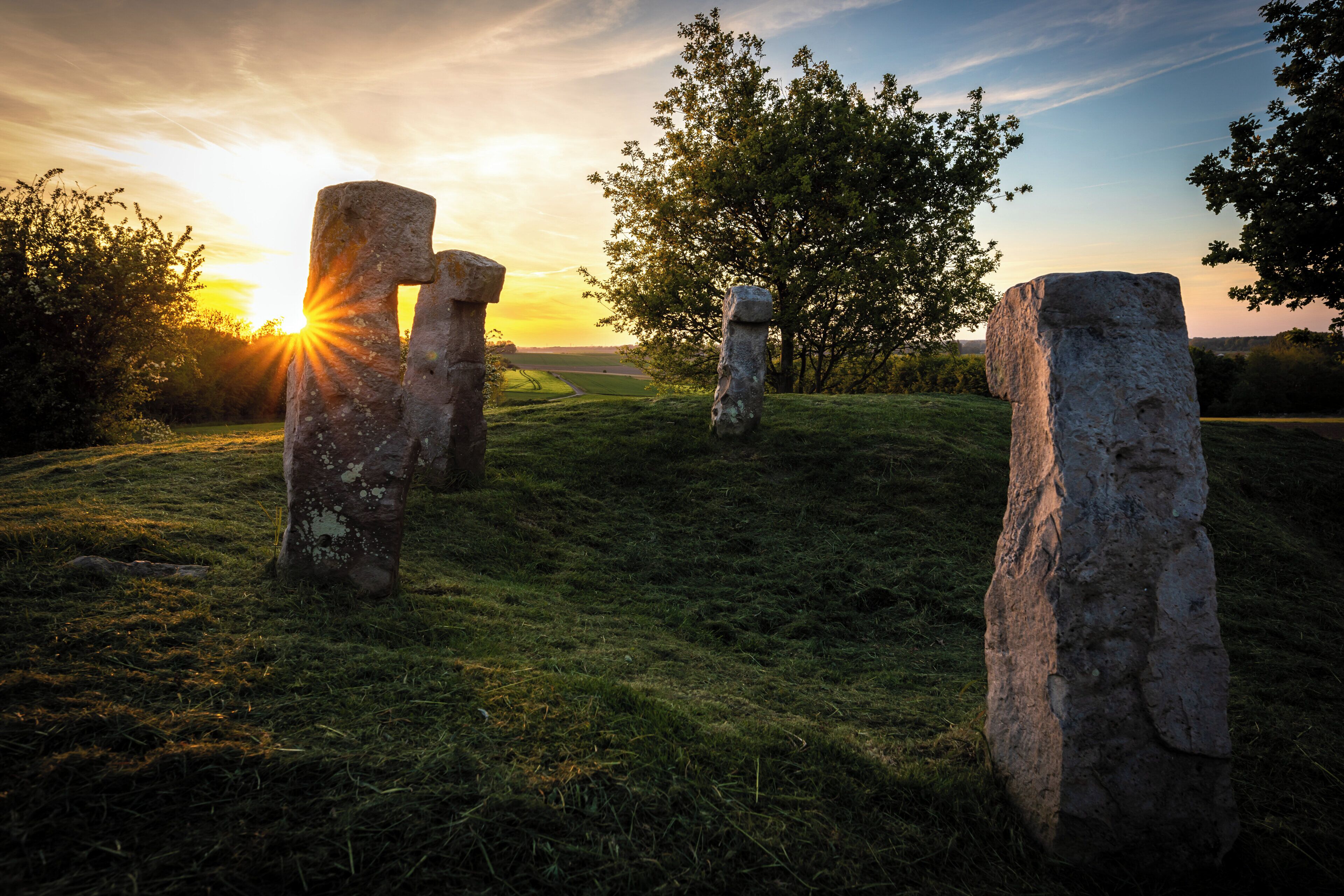 A stone circle with a sunset in the background.