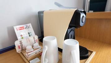 A coffee machine, a tray with cups and a menu, and a wooden table.