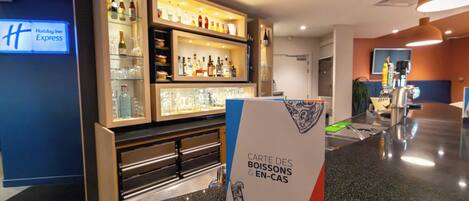 Un bar de hotel con estantes llenos de botellas de licor y vasos, un letrero para el café-bar express, y una barra con un menú.