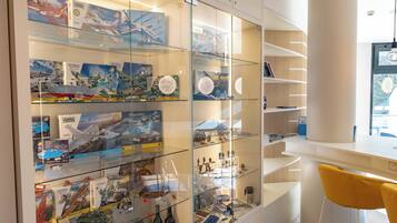 A modern interior with a glass display case filled with model airplanes and military vehicles.