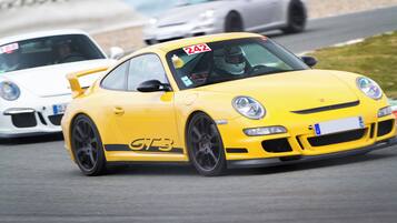 A yellow sports car with racing decals on a track.