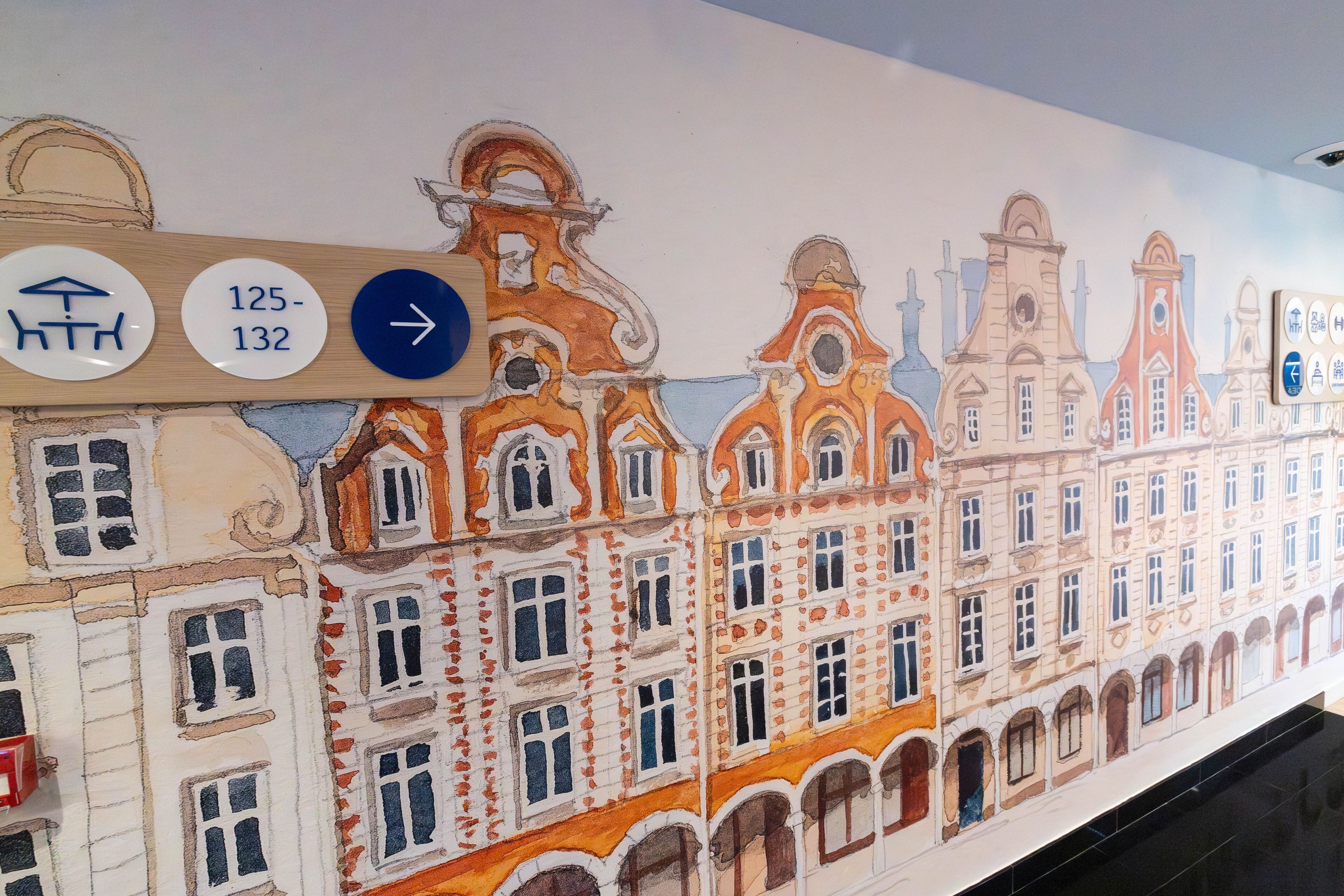 Um mural de um edifício com uma placa indicando direções e números de quartos.