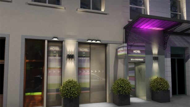 Fachada de un hotel con tres puertas cerradas, cada una con la etiqueta 'HOTEL DE LA CROIX-ROUSSE'. Hay macetas con plantas frente a cada puerta.