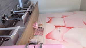 Una cocina moderna con un refrigerador rosa, un lavamanos y una encimera con un salpicadero estampado en rosa y blanco.