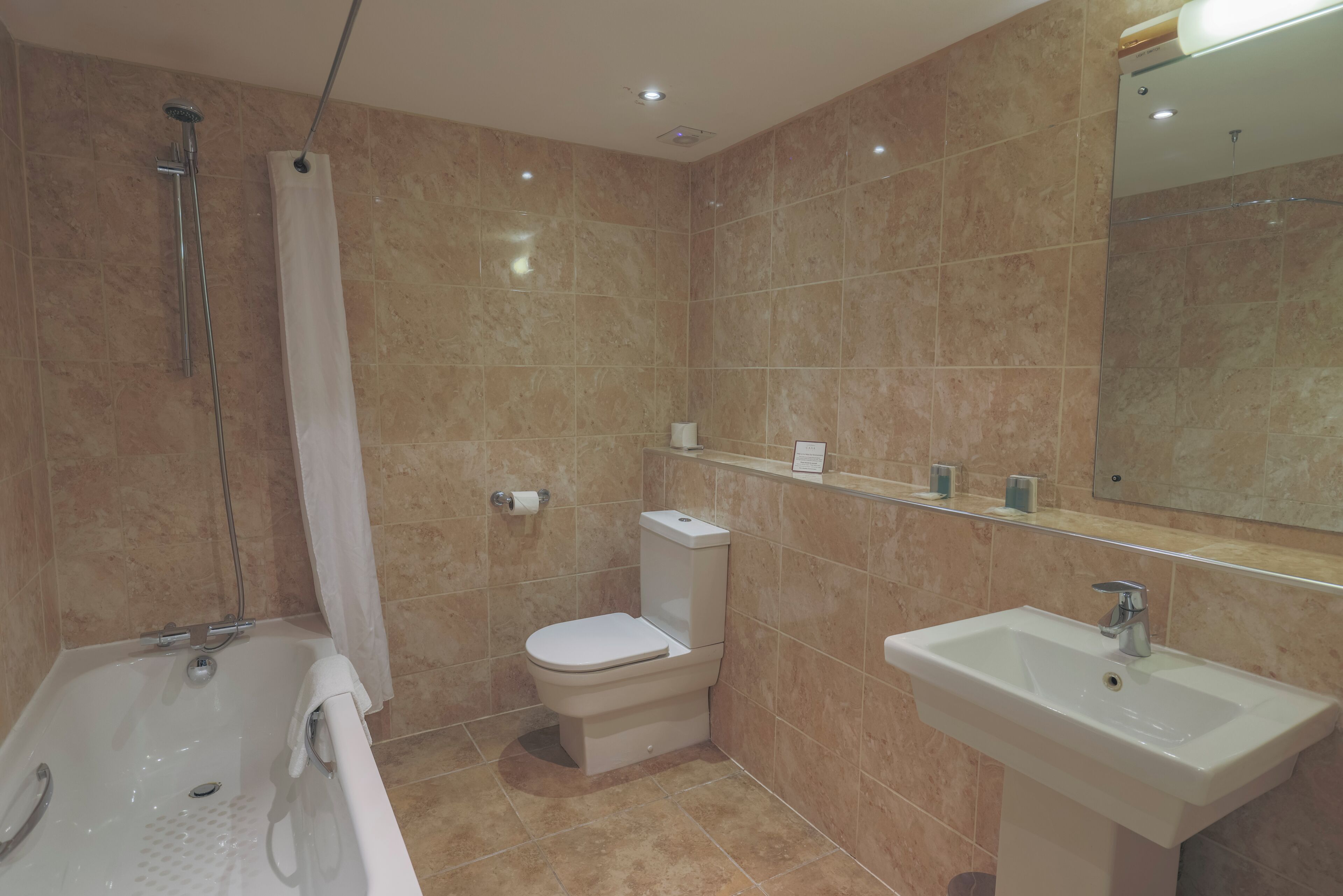 Un baño con bañera, inodoro y lavabo, todo con accesorios modernos.