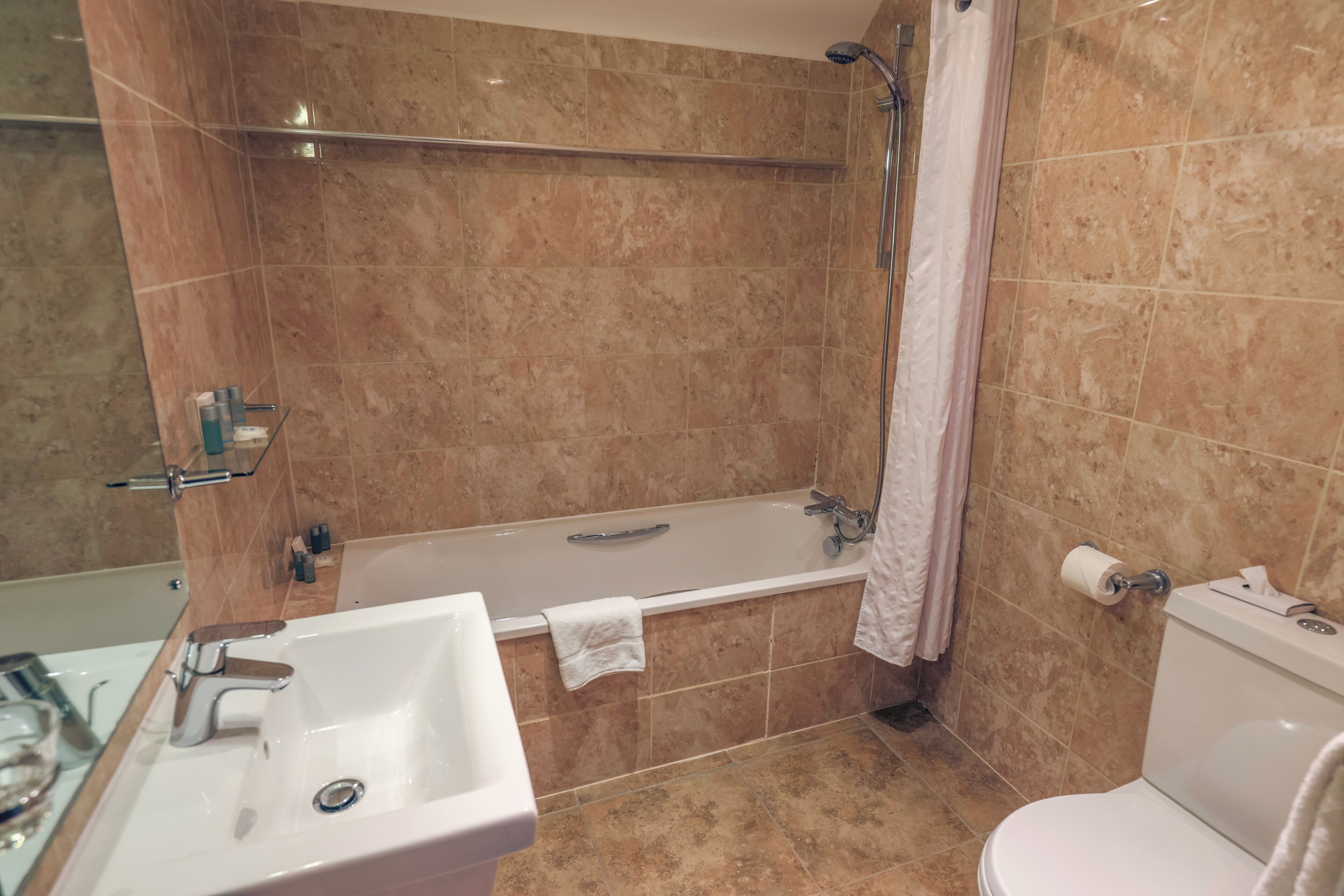 Un baño con bañera, inodoro, lavabo y ducha.