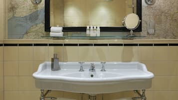 Un bagno con uno specchio grande, un lavandino e due asciugamani appesi al muro.