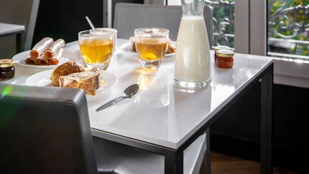 A dining table with a pitcher of milk, glasses of tea, and pastries. - Hôtel du Parc (Paris)