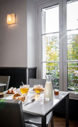 A dining table with a pitcher of milk, glasses of tea, and pastries. - Hôtel du Parc (Paris)