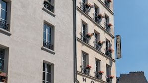 A multi-story hotel with balconies, large windows, and a sign indicating it is a hotel. - Hôtel du Parc (Paris)