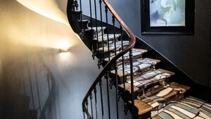 A staircase with a black railing and a patterned carpet. - Hôtel du Parc (Paris)
