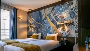 A hotel room with two beds, a large abstract painting on the wall, and a wooden side table. - Hôtel du Parc (Paris)