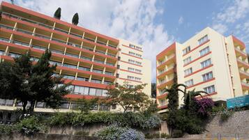 Un hotel de varios pisos con balcones, una pared de piedra y un letrero que indica Hotel Castello Vecchio.