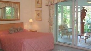 A bedroom with a bed, a nightstand, a lamp, and a window with curtains. - Hayesthorpe Hotel (South Croydon)