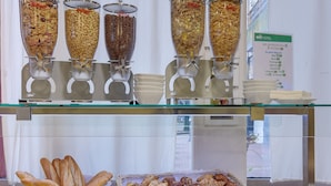 A buffet with various food items, including cereals, bread, and pastries. - Brit Hotel Lille Centre (Lille)