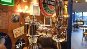 A beer tap with a Heineken logo, a mirror, and a sign for 'Polo'. - Le Voltaire (Rennes)