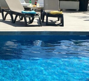 Piscine extérieure, parasols de plage, chaises longues