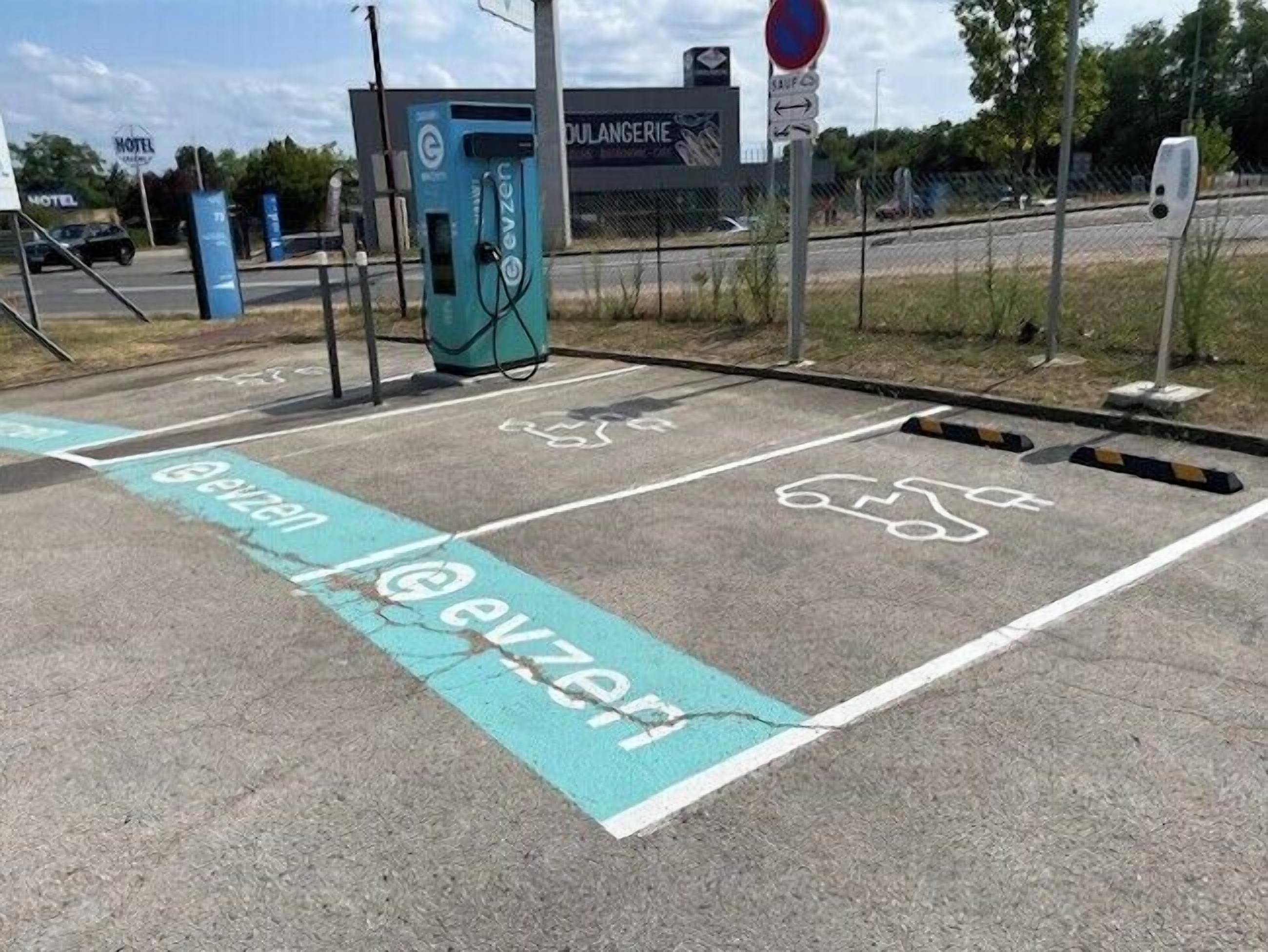 Area di parcheggio con stazioni di ricarica per veicoli elettrici e appositi spazi per biciclette.