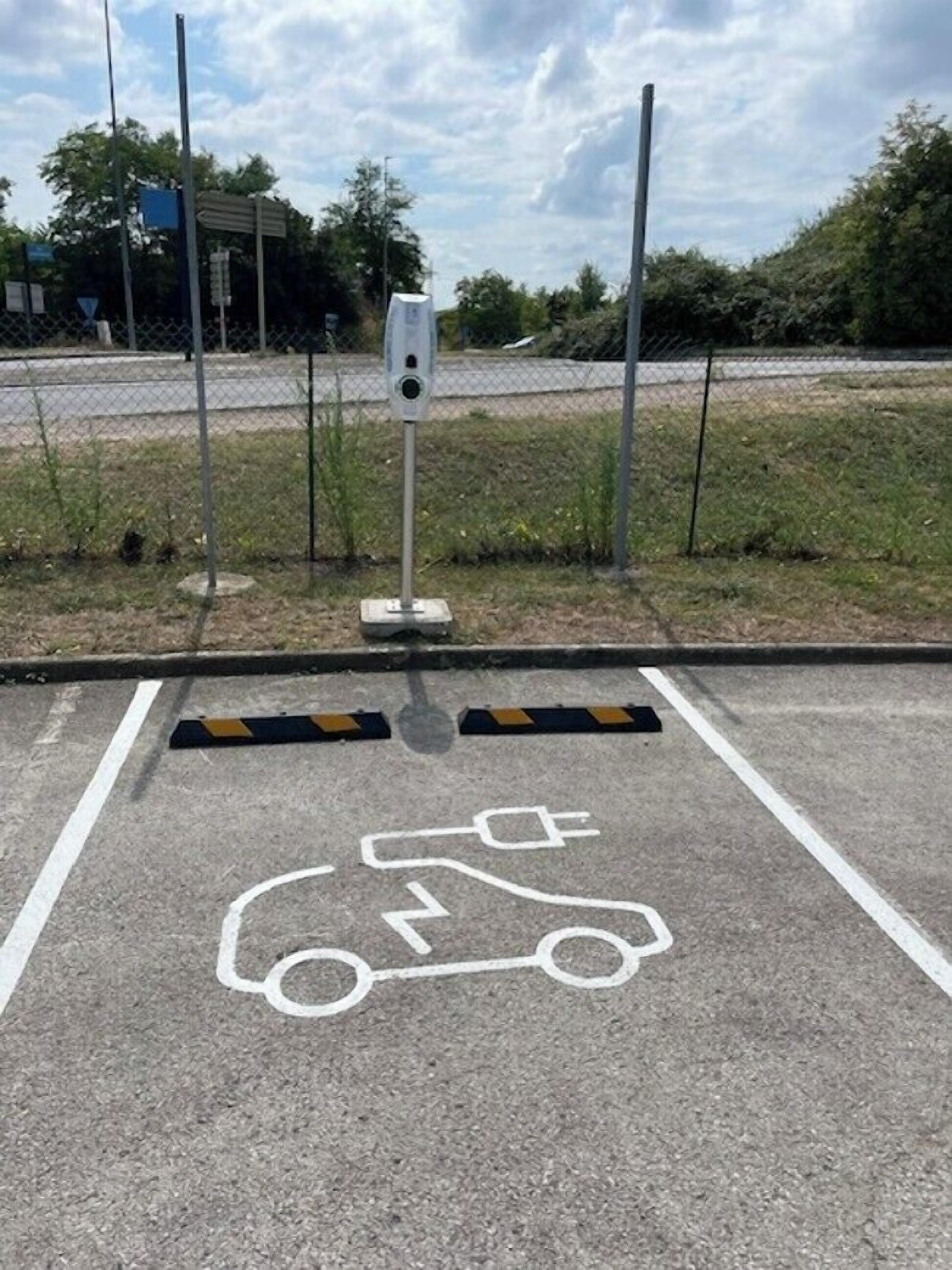Un área de estacionamiento con un espacio reservado para scooter, señalizado con un pictograma blanco en el suelo.