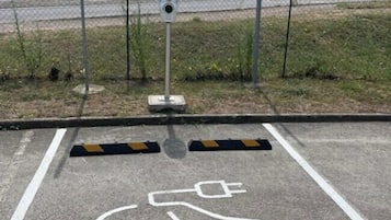 Ein Parkbereich mit einem ausgewiesenen Stellplatz für einen Rollstuhl, gekennzeichnet durch ein weißes Piktogramm auf dem Boden.