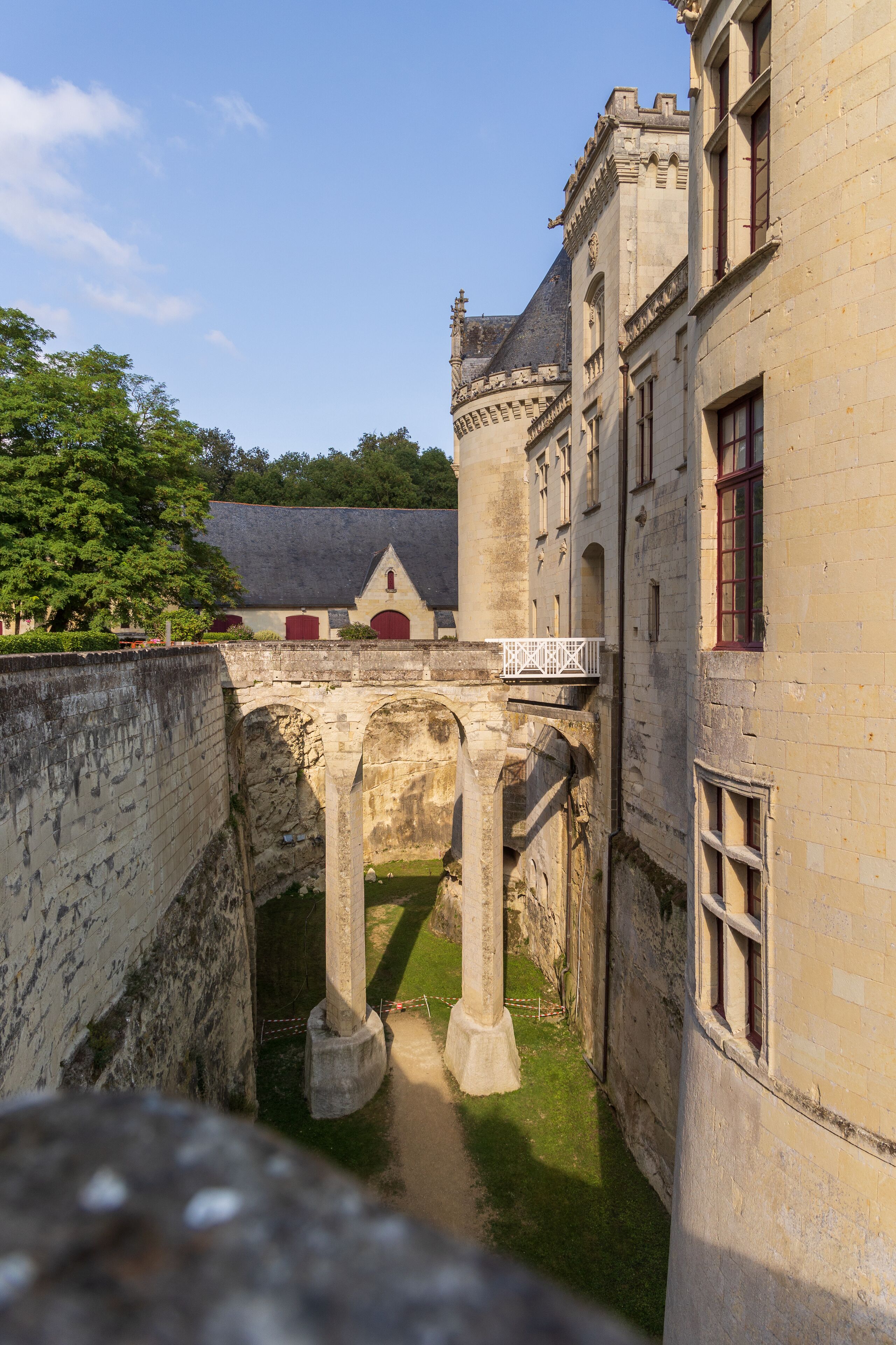 A historic stone bridge connecting two buildings, with a clear pathway and a small garden area.