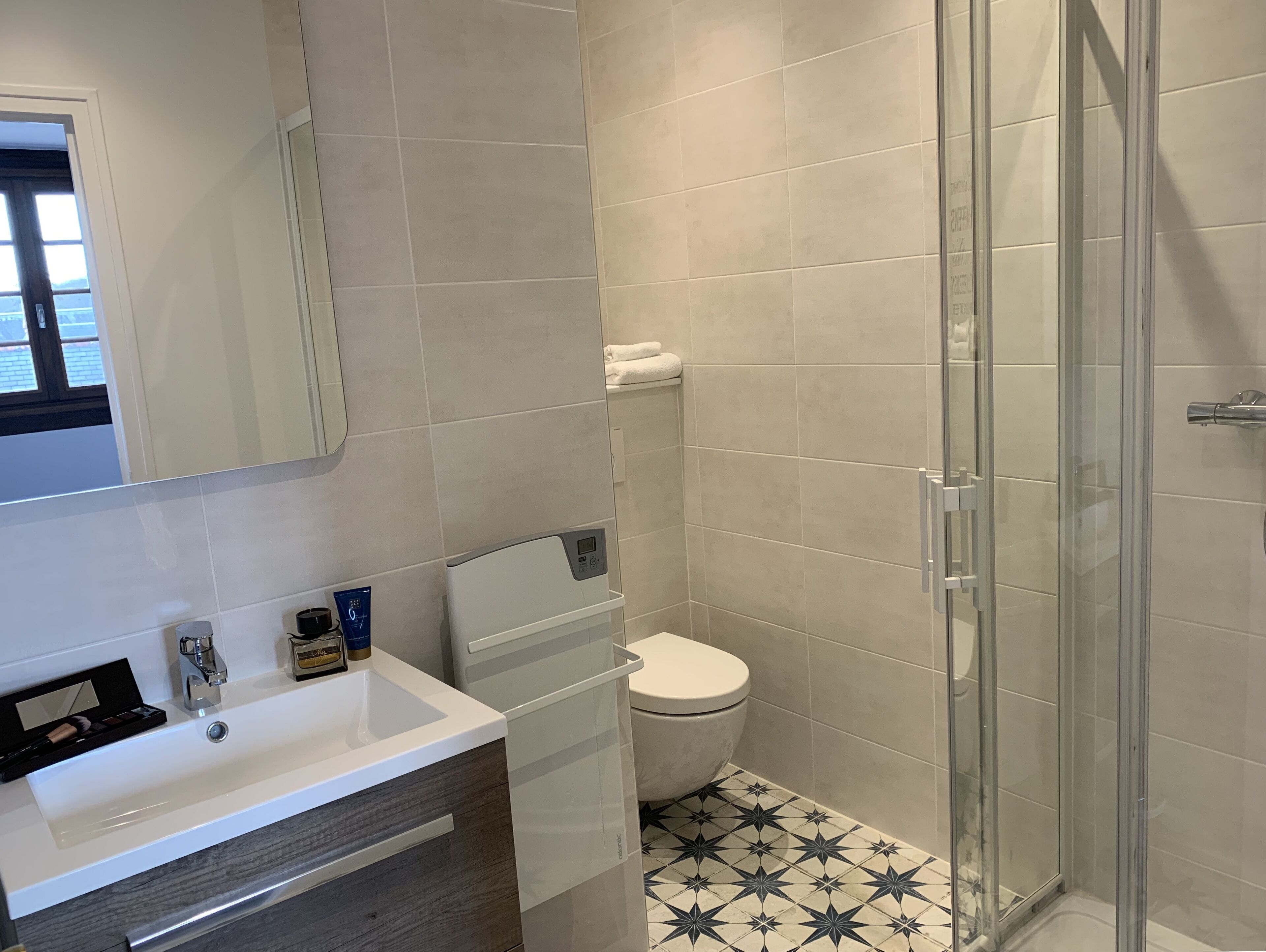 A modern bathroom with a white sink, a glass shower enclosure, and a toilet with a white tank.