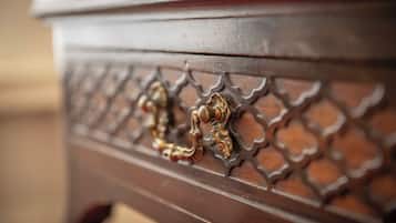 A close-up of a wooden furniture piece with ornate metal handles and a detailed pattern.