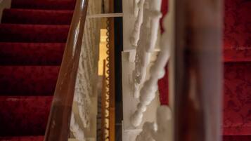 A staircase with red carpeted steps and a white balustrade.