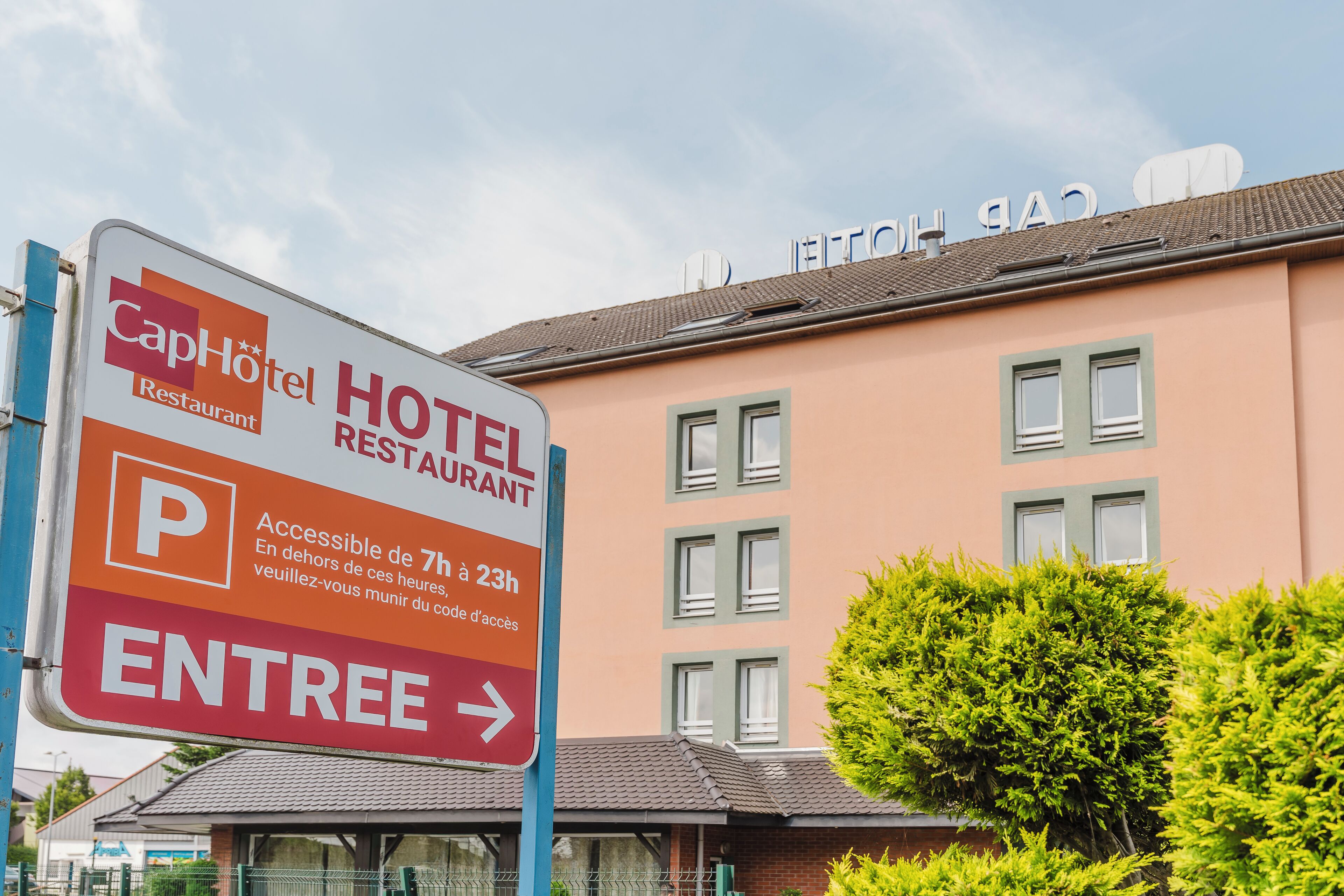 Un panneau d’hôtel indiquant la présence d’un restaurant et d’un parking.