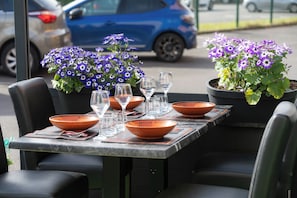Une table à manger avec des chaises, une plante en pot et un bol.