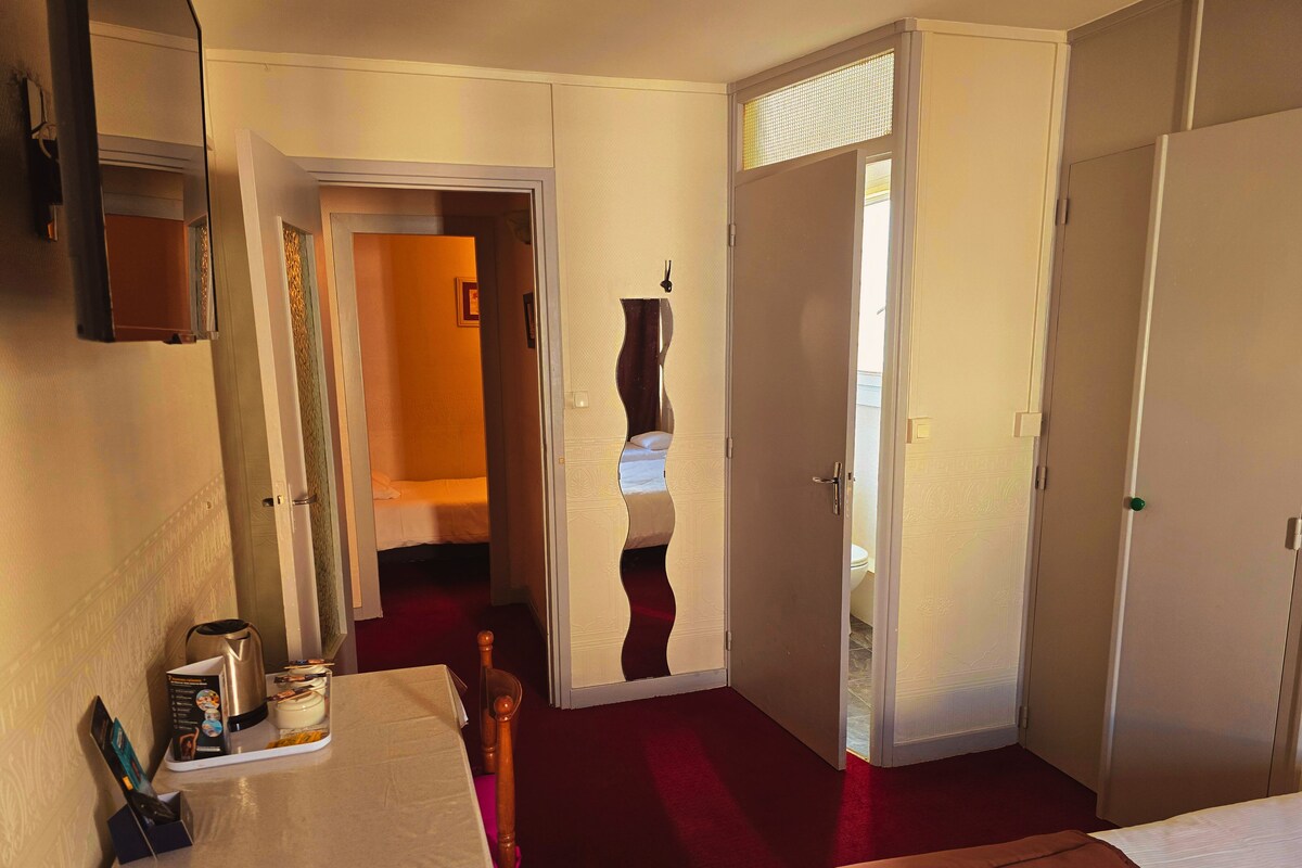 A hotel room with a bed, a desk, and a wardrobe.