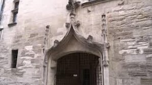 A stone building with a large arched entrance and a small window to the left. - Brit Hotel Acacias (Arles)